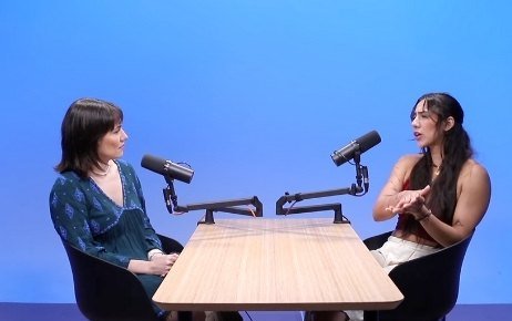 Dos conductoras en mesa con fondo azul