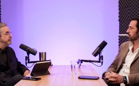 Entrevista en mesa larga con fondo morado